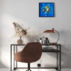 Le tableau bleu Eaux troubles accroché au mur devant un petit meuble et une chaise dans l'esprit minimaliste