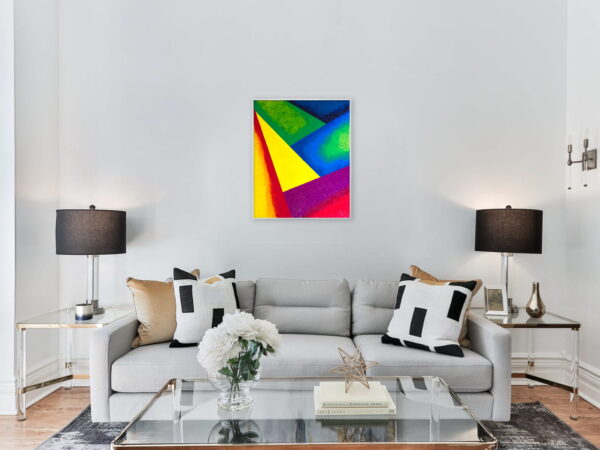 Peinture Montagnes aux couleurs vives et formes géométriques, accrochée au mur d'un salon avec canapé, table en verre et lumières
