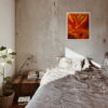 Tableau Automne affichant des couleurs vives et chaudes, accroché au mur d’une chambre moderne avec un lit et des plantes d’intérieur