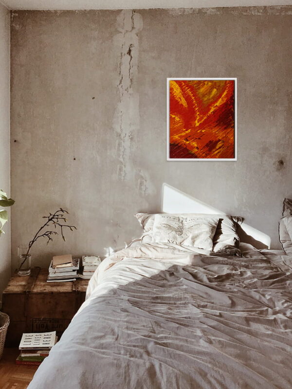 Le tableau Automne est accroché au-dessus d'un lit et met en valeur les couleurs rouges-brunes